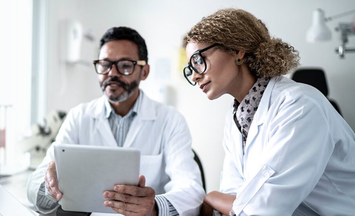 Dos profesionales del cuidado de salud observan un iPad