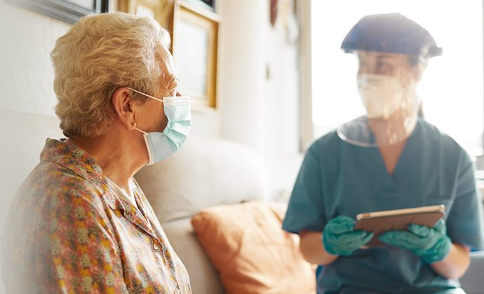 Una médica habla con una paciente sentadas en un sofá.