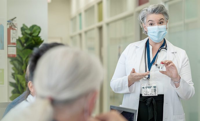 A physician leads an education session in a conference room