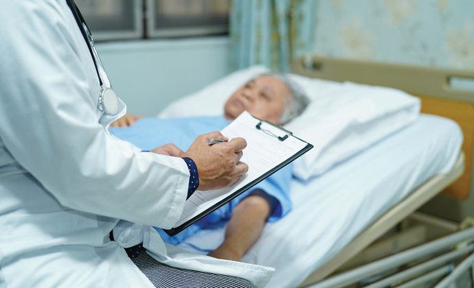 A physician checks on a patient lying in bed