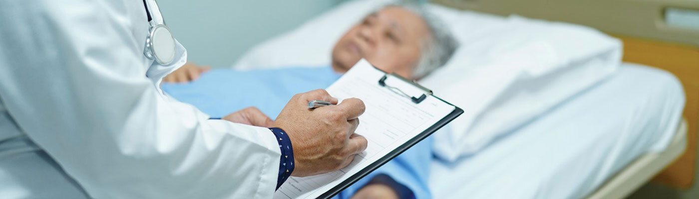 Un médico revisa a una paciente acostada en su cama