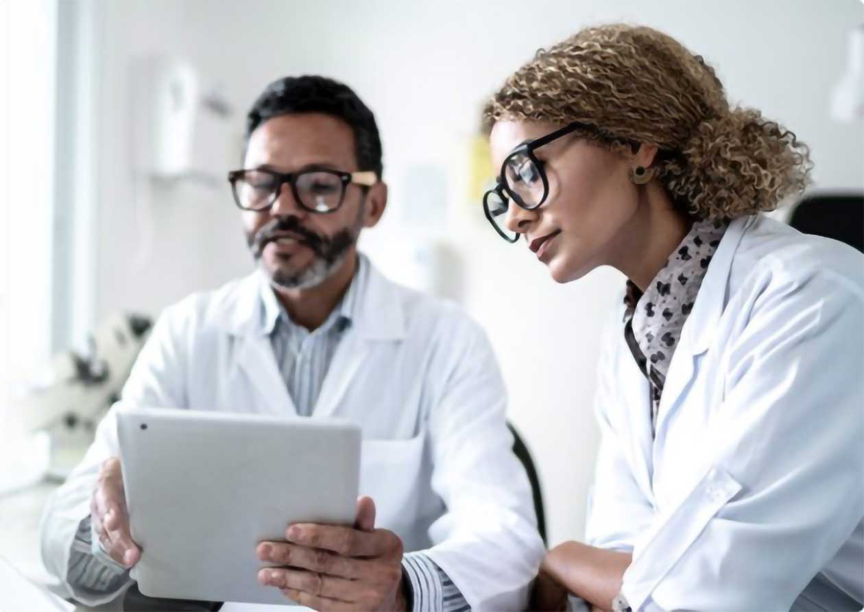 Dos médicos revisan los registros de los pacientes en un iPad