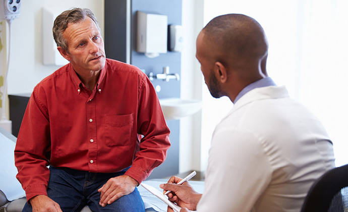 Un médico habla con un hombre en un consultorio