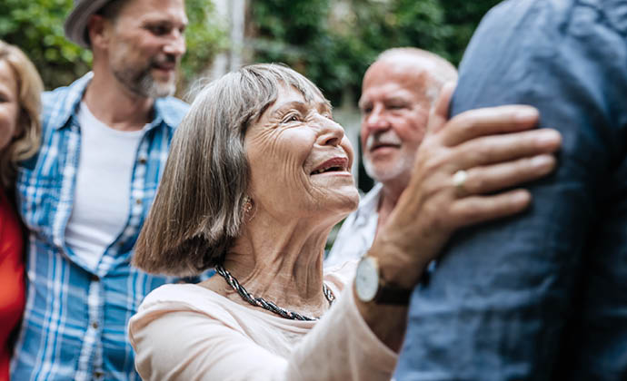 Una mujer habla y sonríe con sus parientes en una reunión familiar