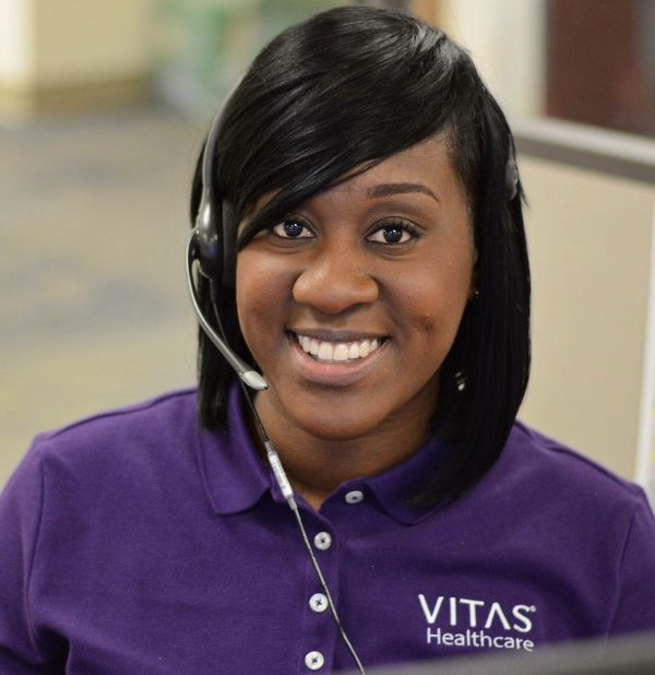 Una representante de servicio al cliente de VITAS con un auricular de teléfono