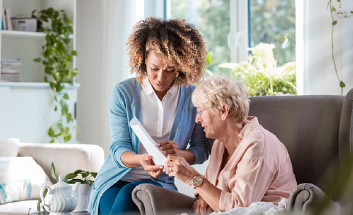 A VITAS volunteer looks at a paper with a patient